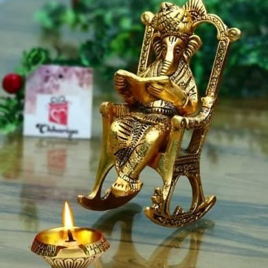 Golden Lord Ganesha Statue Sitting On A Rocking Chair And Reading Ramayan Showpiece